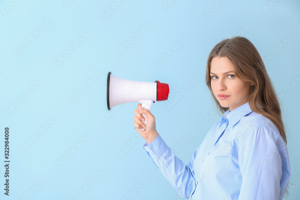 Young businesswoman with megaphone on color background Young businesswoman with megaphone on color background