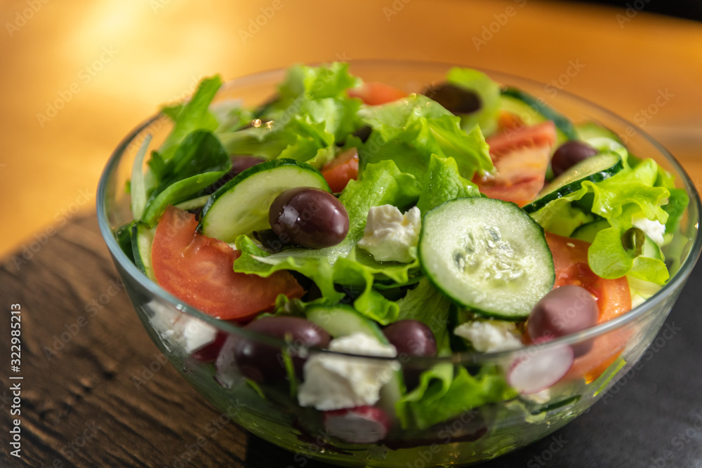 Closeup of freshly made, tasty, delicious, low fat, healthy salad set on a wooden table.