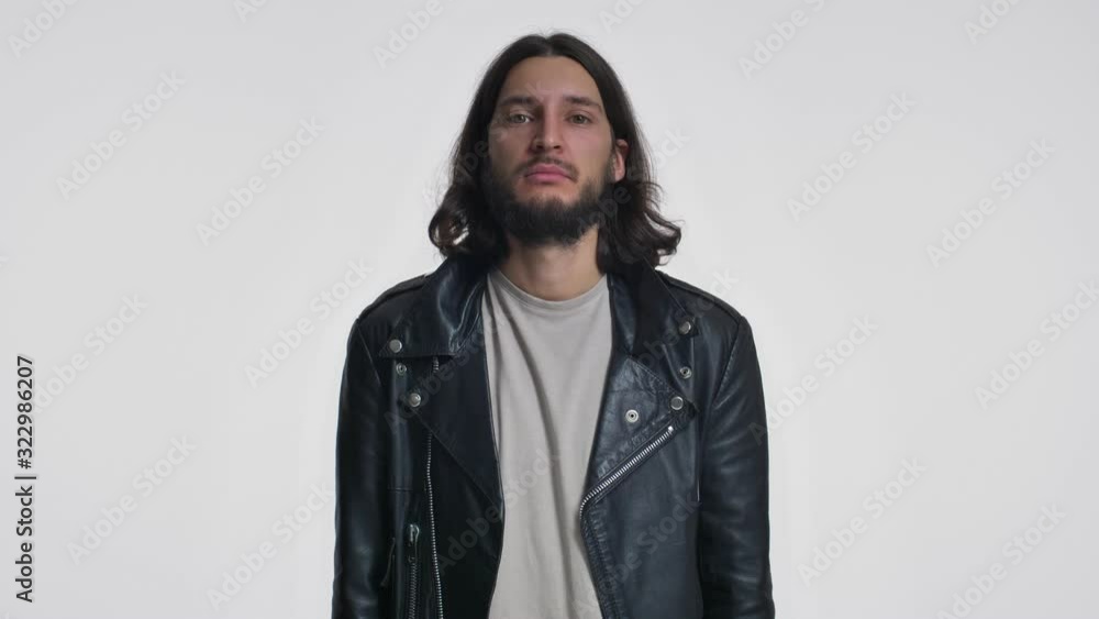 An attractive young man with long hair in a black leather jacket is screaming out isolated over white background An attractive young man with long hair in a black leather jacket is screaming out isolated over white background