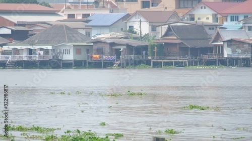 Wooden Houses Along The River In Thailand - wide shot photo