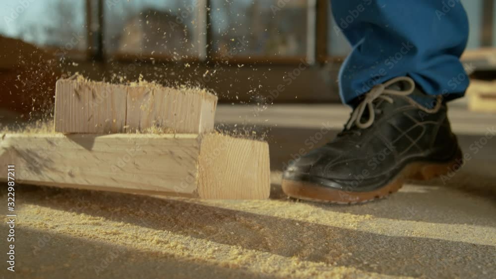 SLOW MOTION, CLOSE UP, DOF: Clumsy contractor cutting wood almost drops ...