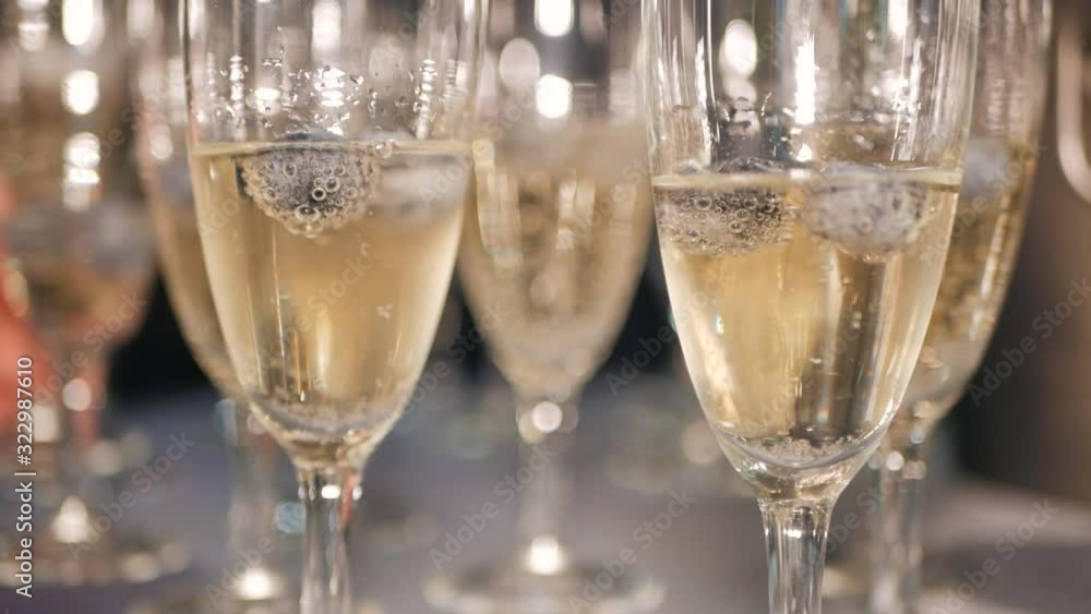 Glasses of champagne with blueberries on the table. The berry floats with bubbles of sparkling white wine. Close up. Glasses of champagne with blueberries on the table. The berry floats with bubbles of sparkling white wine. Close up.