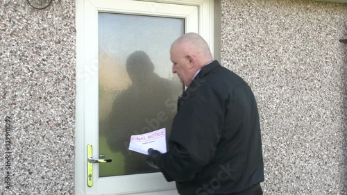 Bailiff / Debt Collector hands Final Notice to woman at her home. Repossession. Repo Man. Stock Video Clip Footage. photo