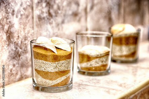 Sand und Muschel in einem glas als schmuck im Badezimmer photo