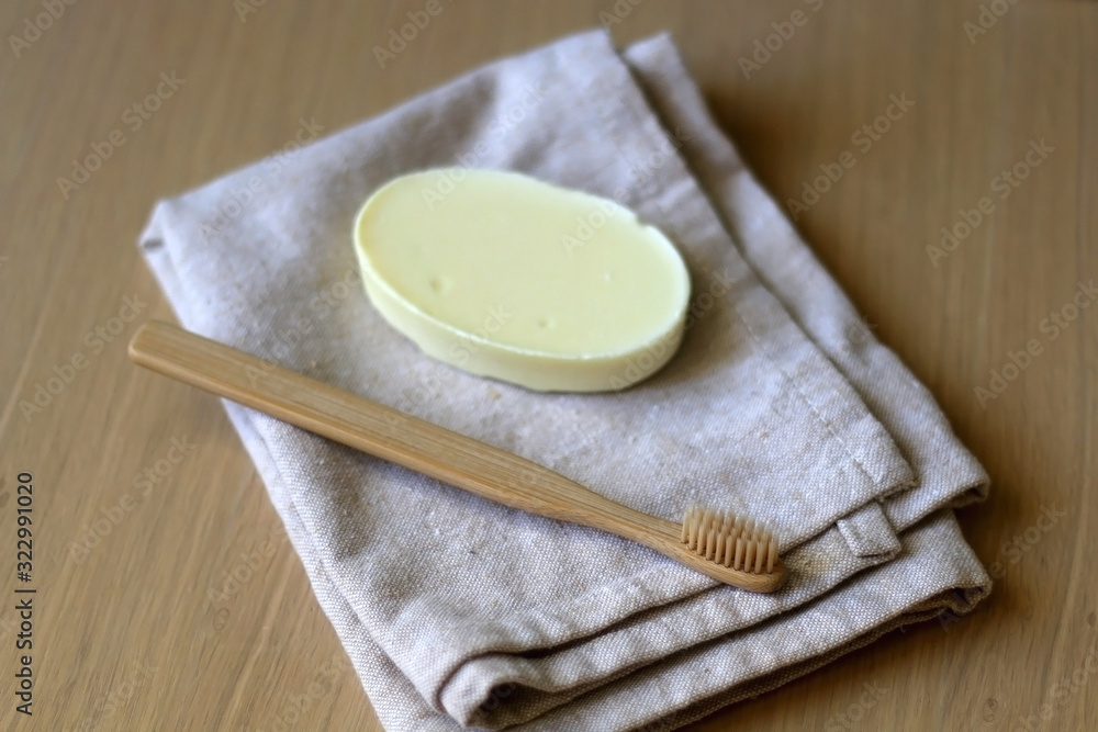 Linen dish cloth, sopa and bamboo toothbrush on wooden table. Selective focus. Linen dish cloth, sopa and bamboo toothbrush on wooden table. Selective focus.
