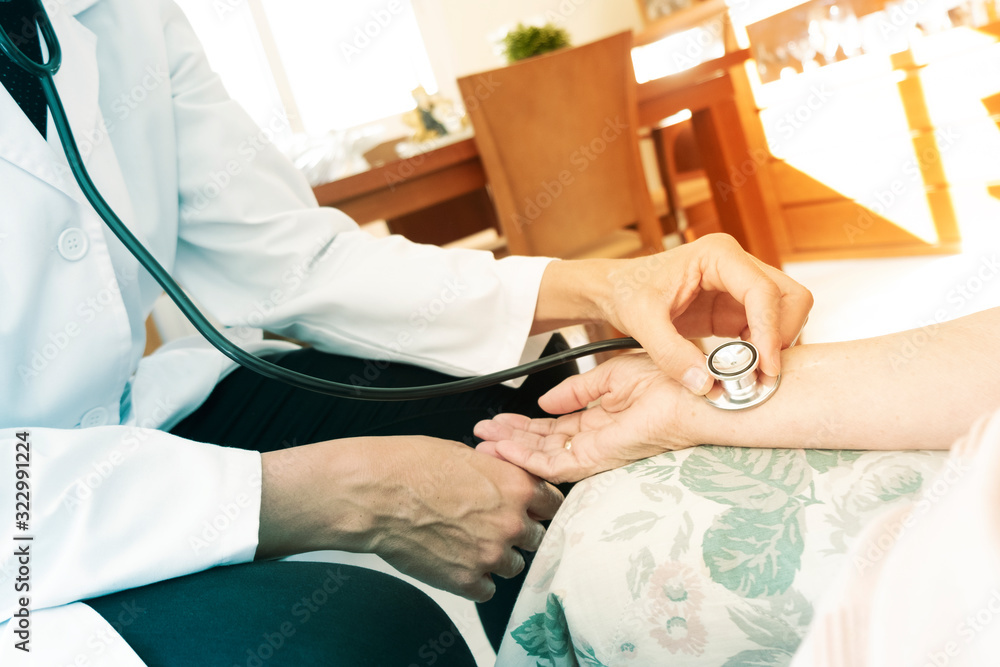 Obraz premium doctor taking the pulse to a senior woman