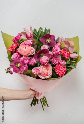 Florist holding a colorful bouquet of flowers in her hand.