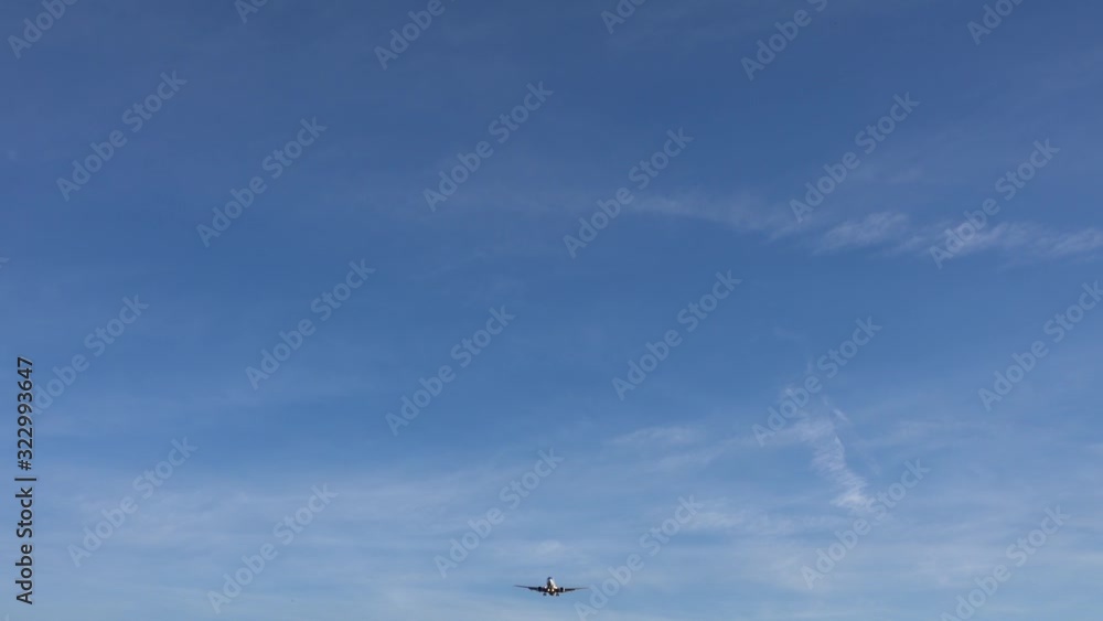 A modern passenger plane appears over the horizon and flies low above the camera. A modern passenger plane appears over the horizon and flies low above the camera.