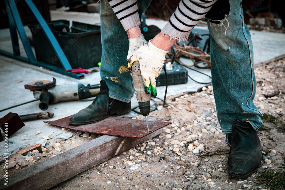 A worker cuts metal at a construction site A worker cuts metal at a construction site