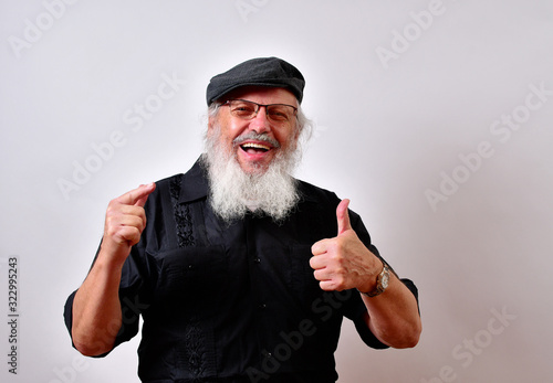 . .Mature gentleman with a newsboy cap and black guayabera shirt and long white beard..