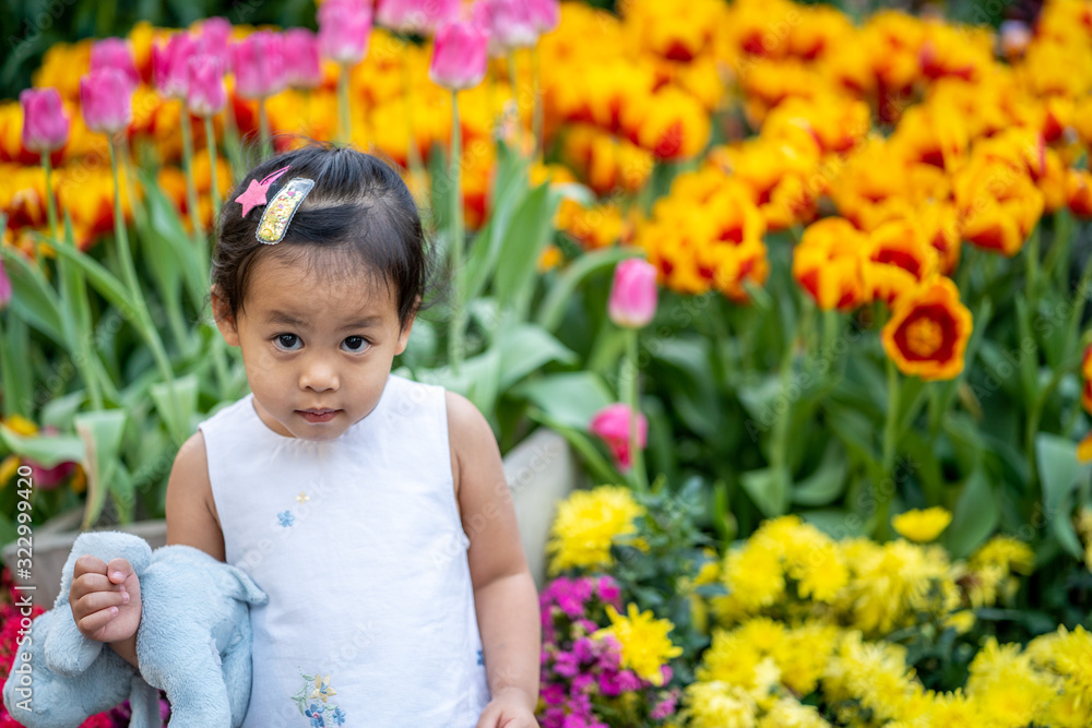 Cute little girl sitting at flower garden in Thailand. Cute little girl sitting at flower garden in Thailand.