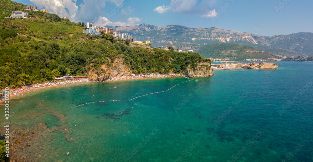 Aerial view of Mogren beach (two sandy beaches) and the old city (stari grad) of Budva. Montenegro. Jagged coast on the Adriatic Sea Aerial view of Mogren beach (two sandy beaches) and the old city (stari grad) of Budva. Montenegro. Jagged coast on the Adriatic Sea