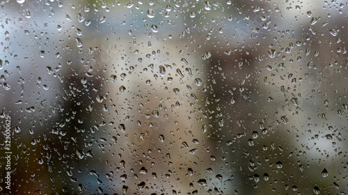 View of the city in a rainy day through a window covered with water drops