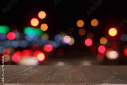 Empty wooden table in front of abstract blurred bokeh light of Cafe  restaurant at night