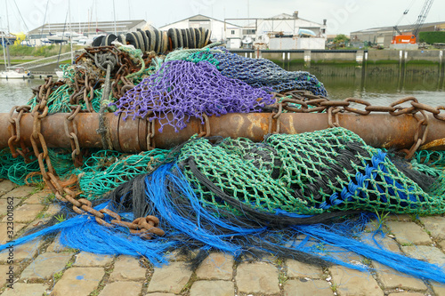 Rusty pull rod with colorful trawl net lying at the quay; Nieuwpoort, Belgium, Europe photo