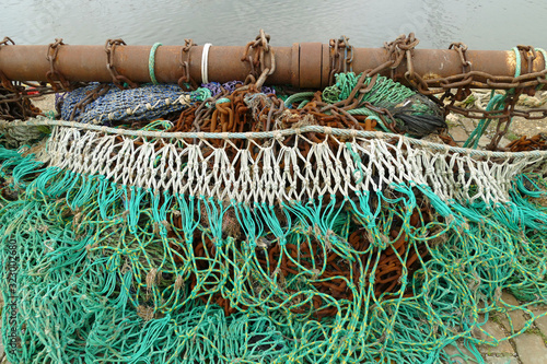 Close-up of a rusty pull rod with colorful trawl net lying at the quay; Nieuwpoort, Belgium, Europe photo