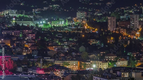 City panorama with illuminated houses and mountains from Old Jewish cemetery night timelapse in Sarajevo. Skyline with traffic. Bosnia and Herzegovina photo