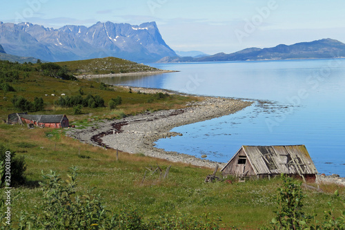 Panorama view of the bay coastline of the beautiful Porsangerfjord at low tide and overcast sky
