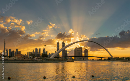A beatiful sunrise from Dubai Canal, focusing on the second pedestrianbridge measures 205x6.5 metres and the floor of the bridge is constructed in an S-Curve shape. The pedestrian bridge is suspended  photo
