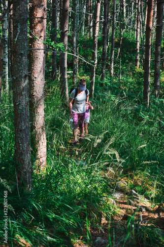 Mom and daughter are walking along a hiking trail in the forest. Koli National park, Finland.