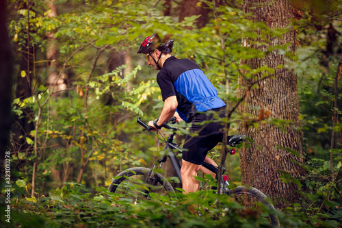 Cyclist in green forest ride bike  .Spring, nature ,sport concept