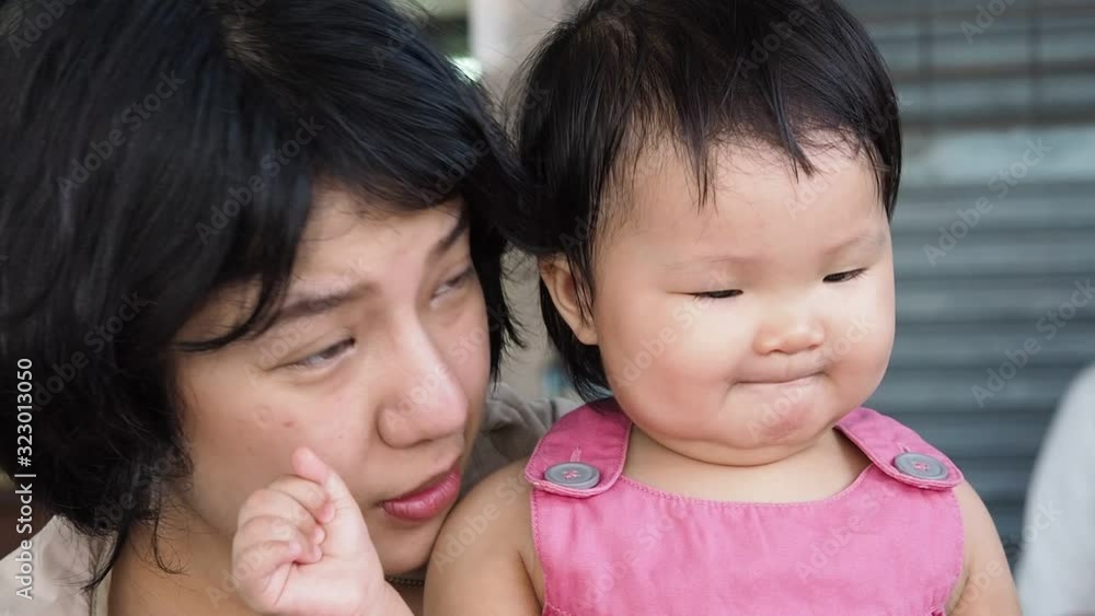 Close up cute asian infant baby girl and pretty asian woman taking together at the table with happy emotion.Concept is family,mother and daughter.Slowmotion. Close up cute asian infant baby girl and pretty asian woman taking together at the table with happy emotion.Concept is family,mother and daughter.Slowmotion.