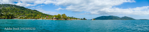 View of coastline on Nosy Komba Island lined with palm trees and , Madagascar close to Nosy Be