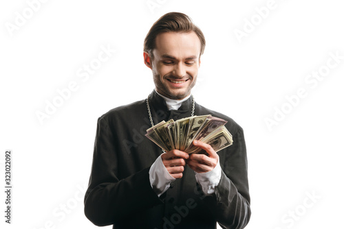 corrupt catholic priest smiling while holding dollar banknotes isolated on white