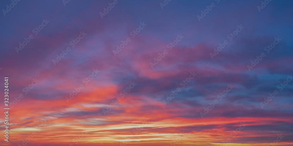 Twilight sky and clouds panorama with orange and blue hues