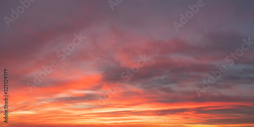 Twilight sky and clouds panorama with orange hues
