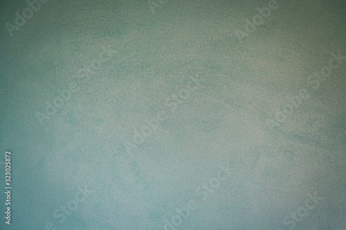 Soft turquoise teal aqua rustic rough-textured cement wall with a slight vignette