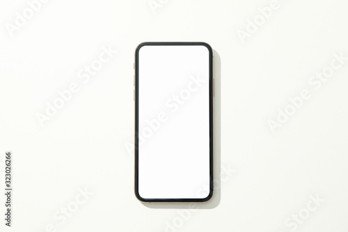 Phone with empty screen on white background, top view