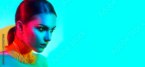 High Fashion model woman in colorful bright lights posing, portrait of beautiful sexy girl with trendy make-up. Art design, colorful make up. Over colourful vivid background. Night club dancer, UV