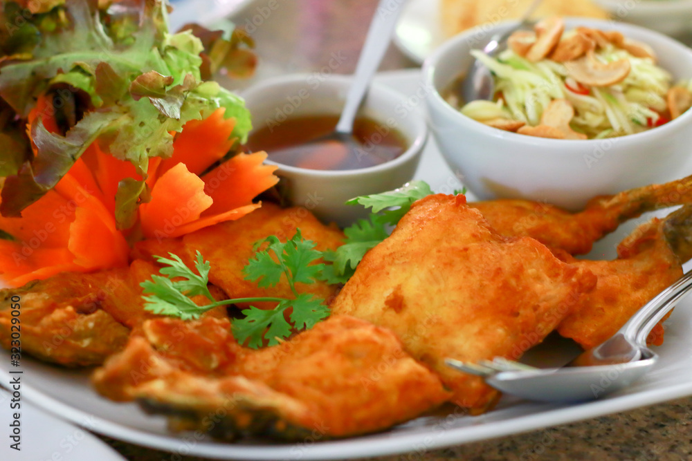 Thai food. Fried fish with fish sauce and side dishes sauce mix in vinegar and sugar with ingredient mango slices, chili, and cashew nuts. Thai food. Fried fish with fish sauce and side dishes sauce mix in vinegar and sugar with ingredient mango slices, chili, and cashew nuts.