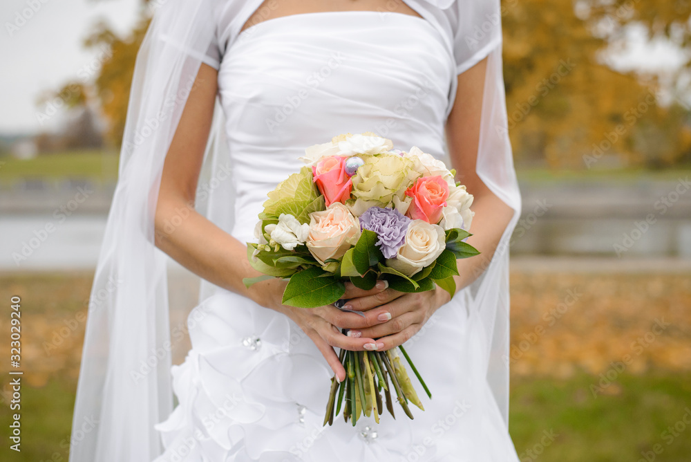 Bright wedding bouquet of roses, Queens, decorative cabbage and green leaves in the hands of the bride Bright wedding bouquet of roses, Queens, decorative cabbage and green leaves in the hands of the bride