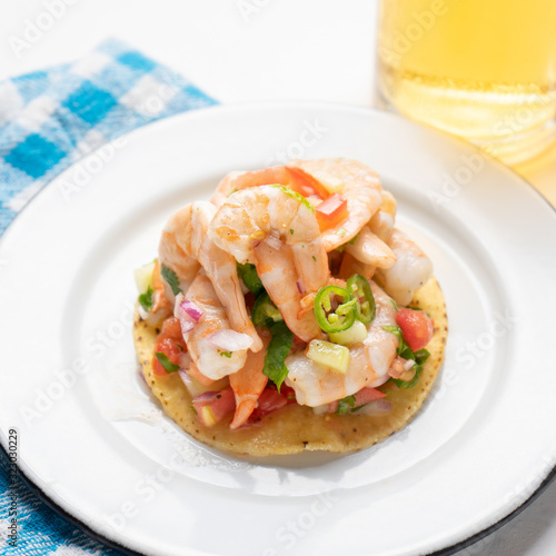 Mexican shrimp ceviche toast also called tostada on white background