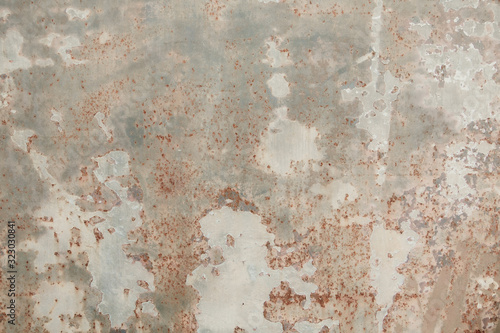 Fototapeta Naklejka Na Ścianę i Meble -  Rough textured cement concrete  wall with varying shades of gray, brown and cream with peeling layers