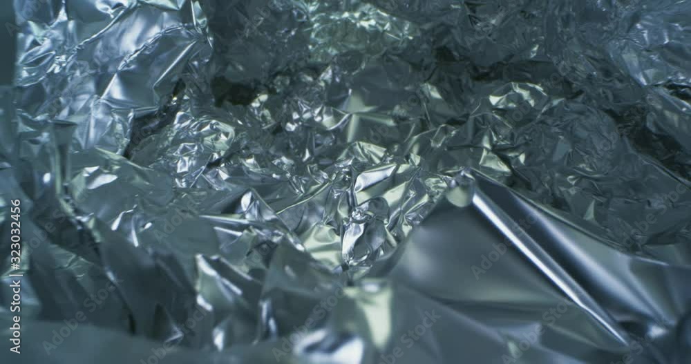 Crumpled, Aluminium Foil Shining In The Spotlight. Endless, Abstract Pattern. Macro. Crumpled, Aluminium Foil Shining In The Spotlight. Endless, Abstract Pattern. Macro.