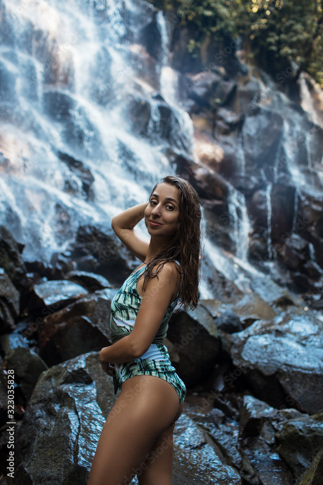 Beautiful sexy girl under Kanto Lampo waterfall in Indonesia.