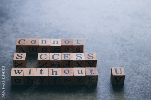 Wood cube letter word of Cannot SUCCESS without U. Idea of motivation and inspiration in business vision and corporate management strategy. Leadership lead teamwork to reach achievement. photo