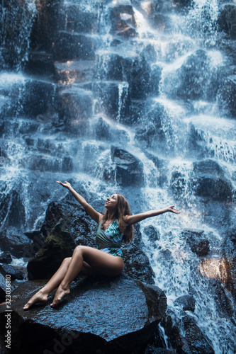 Beautiful sexy girl under Kanto Lampo waterfall in Indonesia.