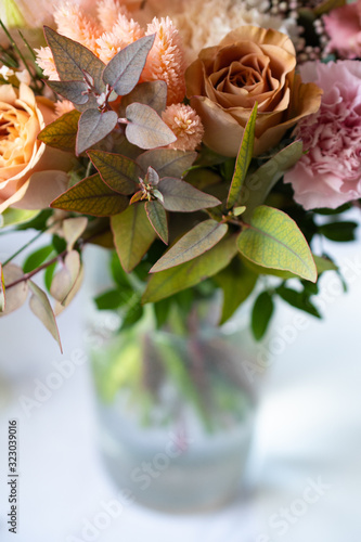 Bouquet of different flowers in a glass vase on the table