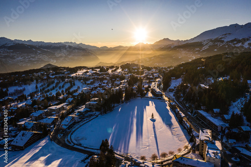 Stunning sunset over the Crans Montana village, above the Rhone valley, in Valais, Switzerland on a sunny winter evening.