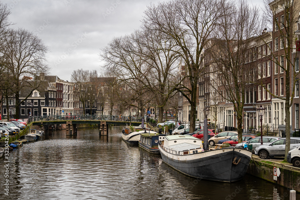 Houseboats anchored on a canal in the center of Amsterdam city on a cold witner day in the Netherlands
