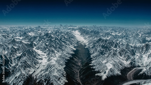 Incredible and majestic Himalayan mountains and visible Everest in the distance. View from above. Sunny, bright day.
