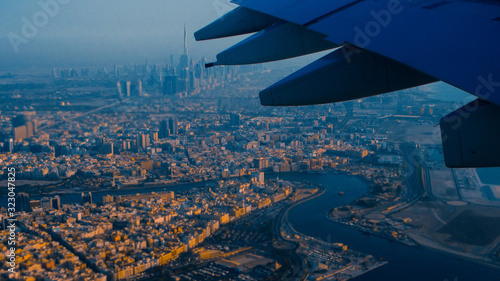 View of Dubai from the airplane window, sunset time and rich colors.