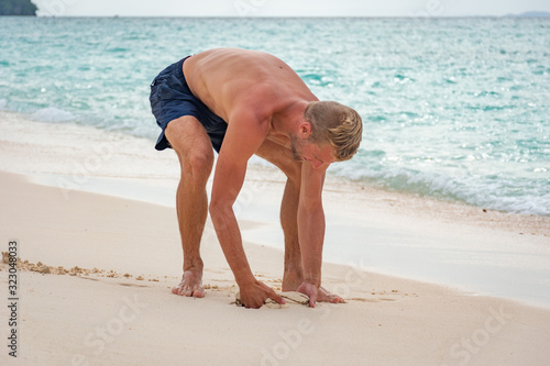 Portrait beau gosse charmant jeune homme caucasian blond aux yeux bleu joyeux confiance en soi séduisant chanceux charismatique européen heureux zen thailand île ko phi phi ko lanta plage sable blanc