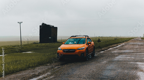 orange car parked in a foggy ghost town
