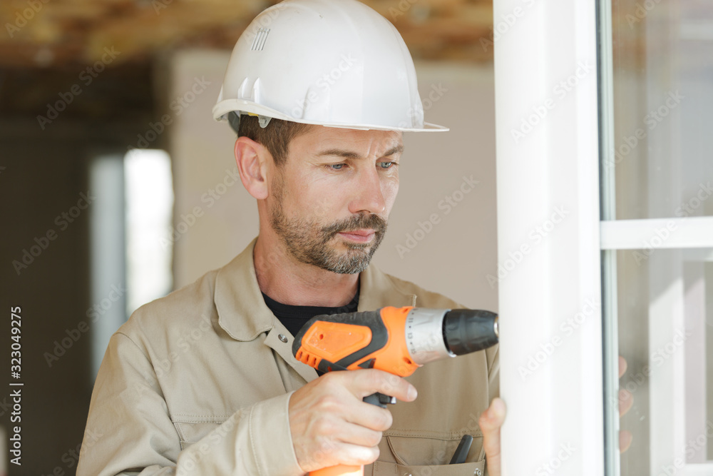a man drilling a window frame a man drilling a window frame