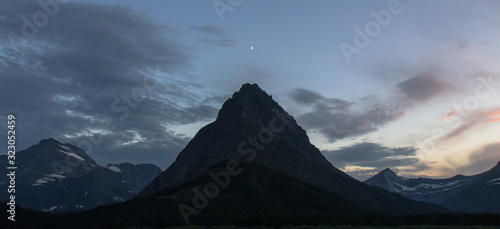 mountain peak with moon rising above